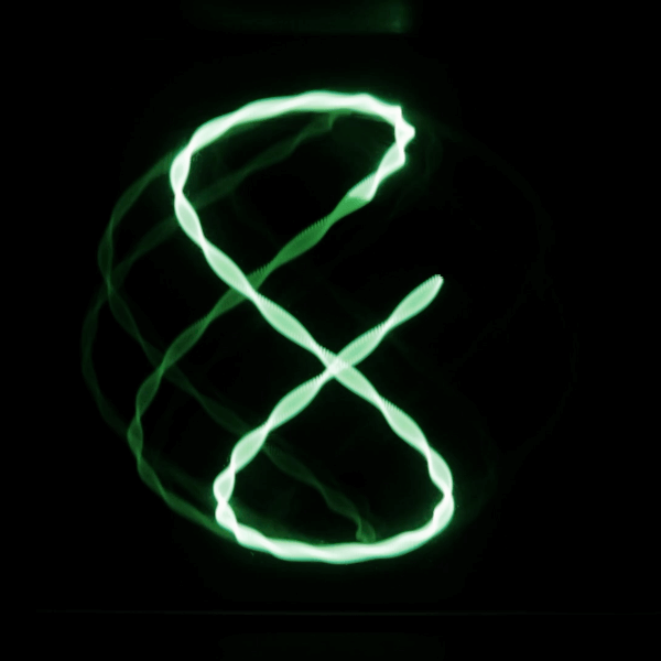 a green lissajous figure on a black background. The lissajous figure is drawn on an oscilloscope