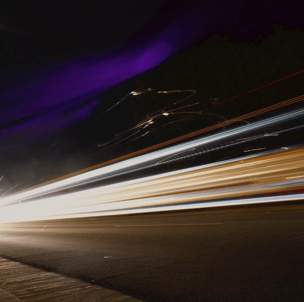 long exposure image of a car crossing from left to right.